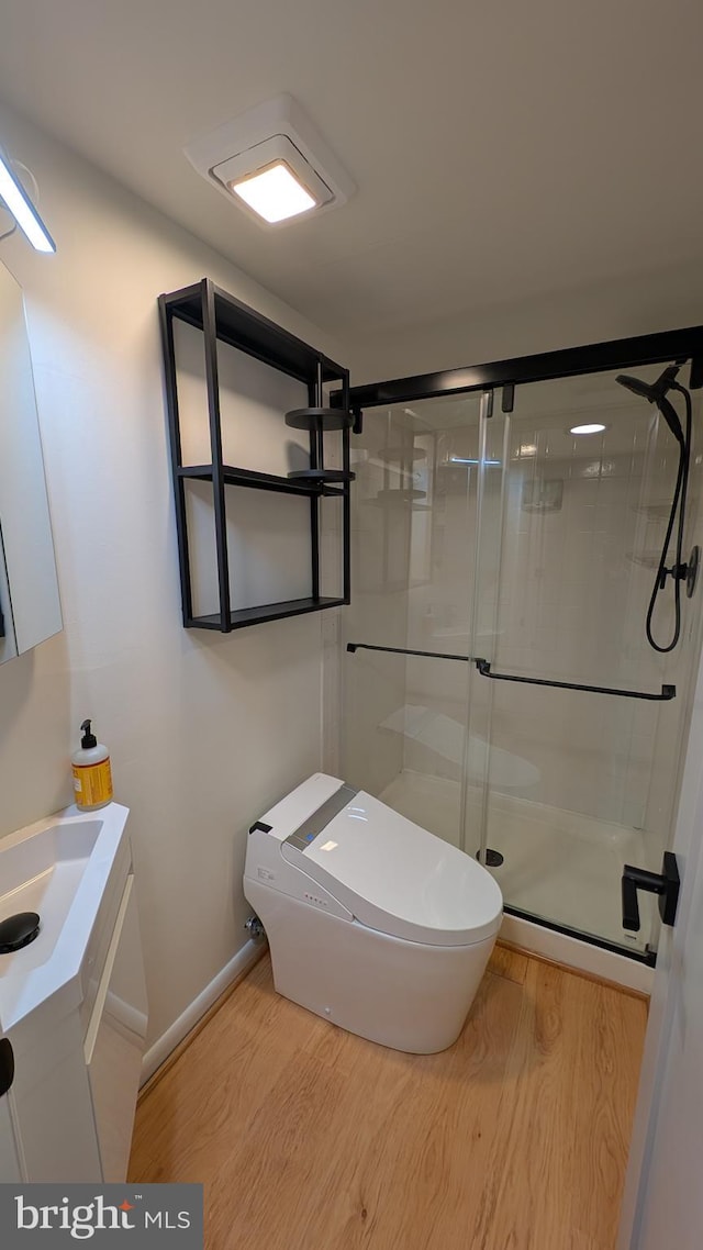 bathroom featuring toilet, an enclosed shower, wood-type flooring, and vanity