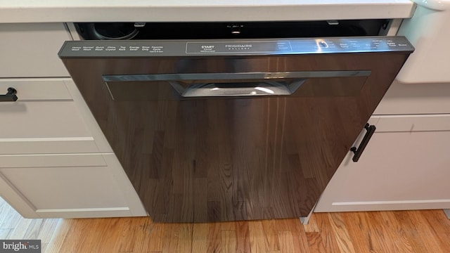 interior details featuring dishwasher and light hardwood / wood-style flooring