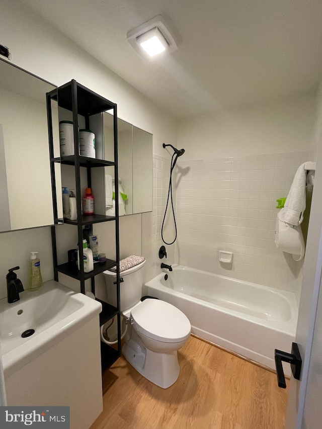 full bathroom featuring vanity, toilet, wood-type flooring, and tiled shower / bath