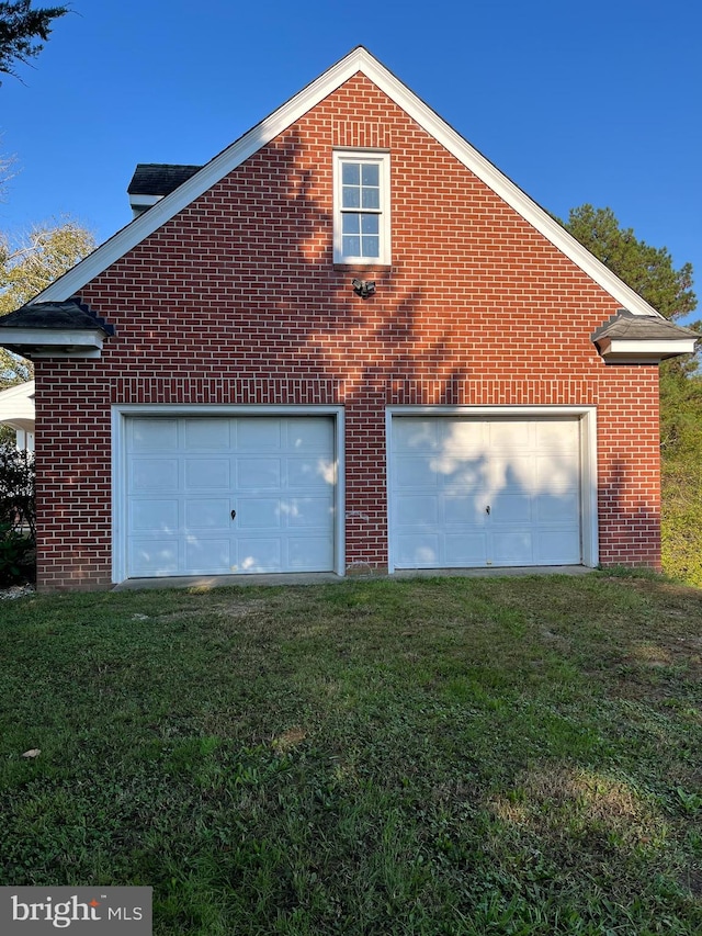 exterior space with a garage and a lawn