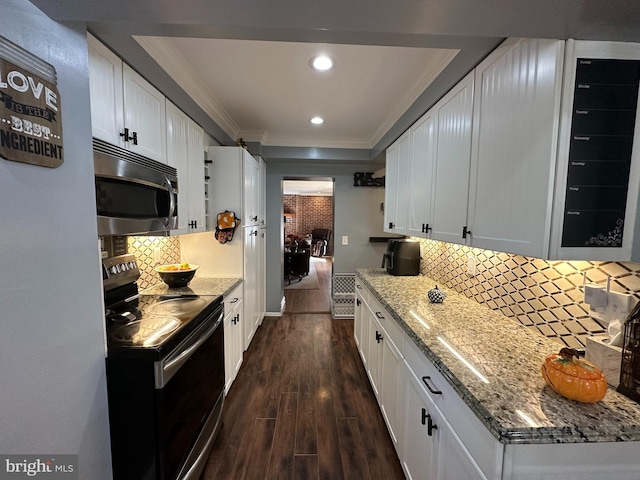 kitchen with appliances with stainless steel finishes, dark hardwood / wood-style floors, white cabinetry, and tasteful backsplash