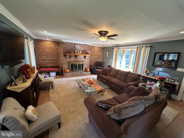 living room with a fireplace, hardwood / wood-style floors, ceiling fan, brick wall, and ornamental molding