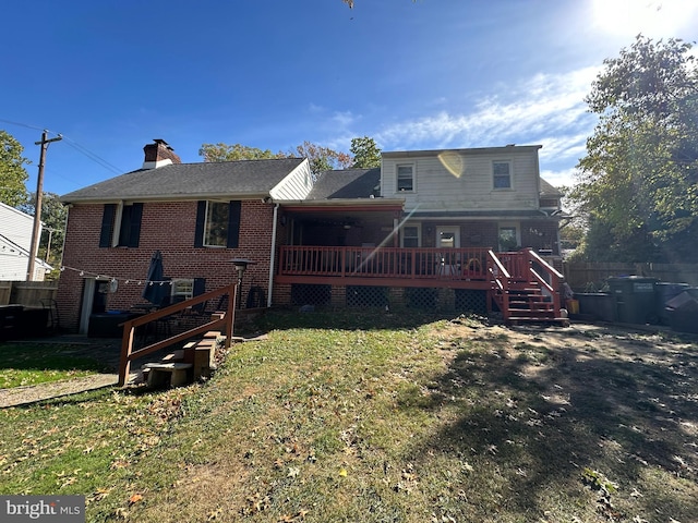 rear view of house with a wooden deck and a lawn