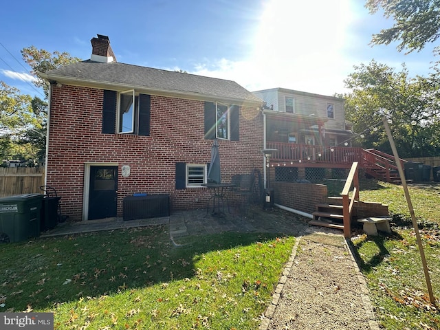 rear view of house with a patio area, a deck, and a lawn