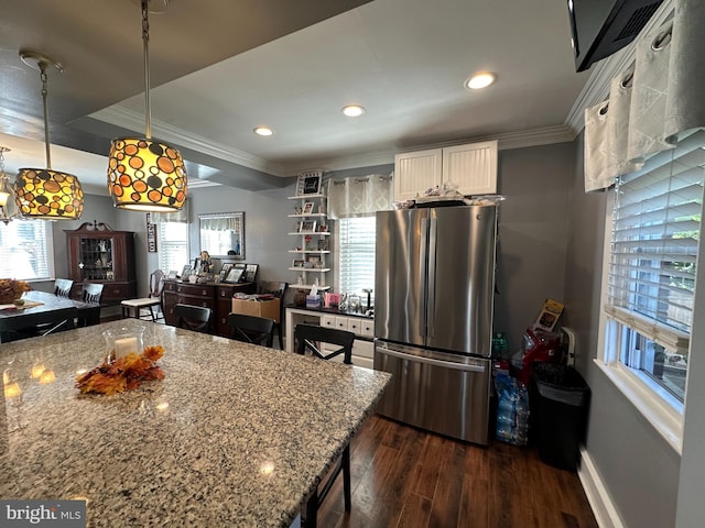 kitchen featuring white cabinets, light stone counters, dark wood-type flooring, and stainless steel refrigerator