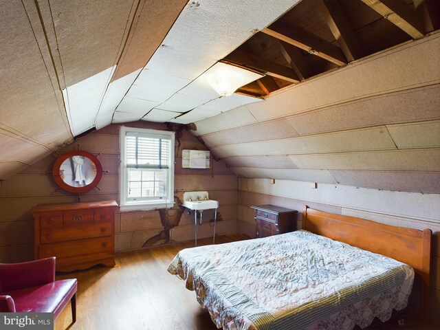 bedroom with light hardwood / wood-style flooring and vaulted ceiling