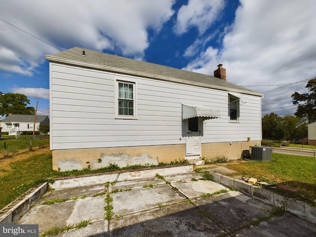 back of house featuring a yard and central AC