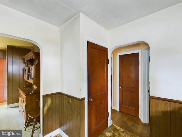 corridor featuring wood walls and dark hardwood / wood-style floors