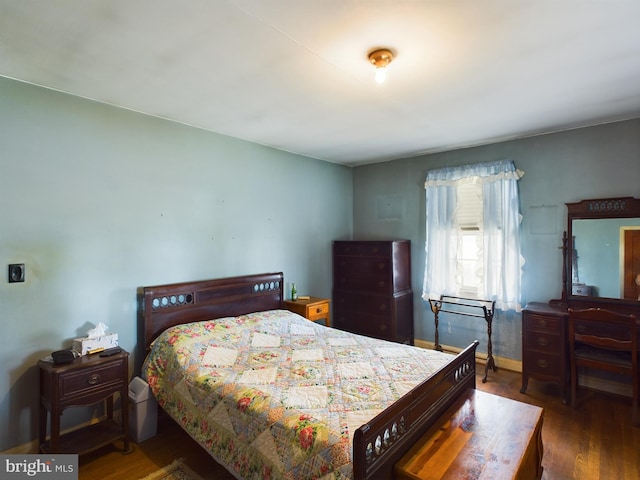 bedroom with dark hardwood / wood-style floors