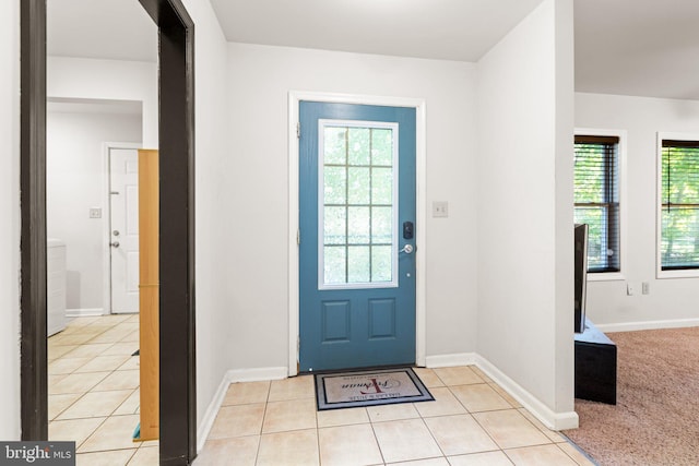 entrance foyer featuring a wealth of natural light, light tile patterned flooring, and baseboards