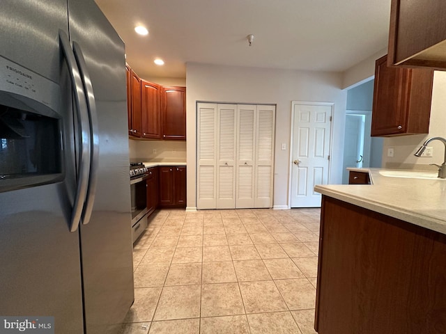 kitchen with sink, light tile patterned flooring, and stainless steel appliances