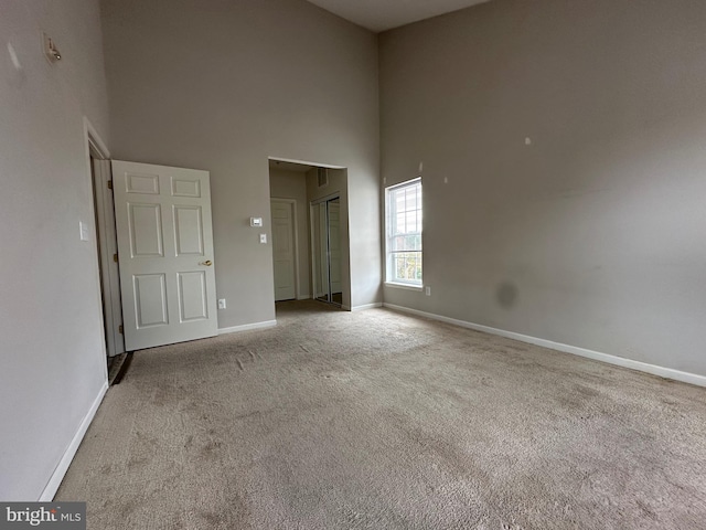 spare room with light carpet and a high ceiling