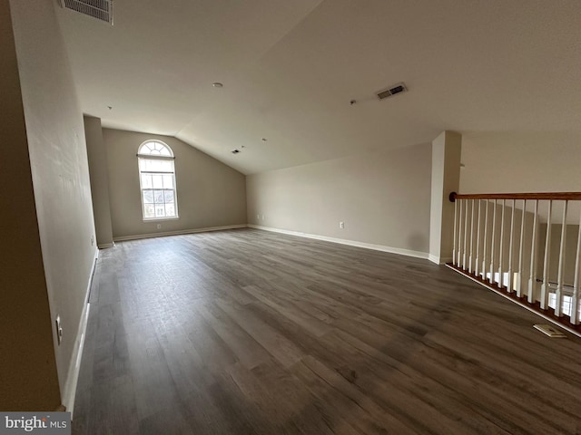 additional living space featuring dark hardwood / wood-style floors and lofted ceiling