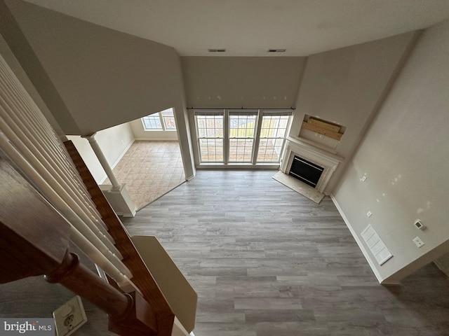 unfurnished living room with a towering ceiling and hardwood / wood-style flooring