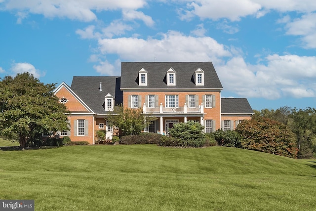 view of front of house with a front yard and a balcony