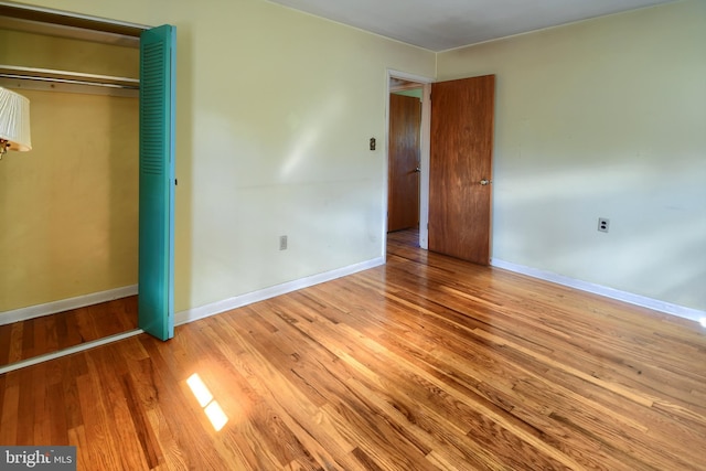 unfurnished bedroom with hardwood / wood-style flooring and a closet