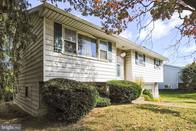 view of front of house featuring a front lawn and a garage