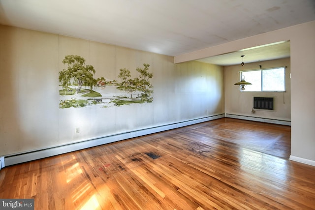 unfurnished room with a baseboard heating unit and wood finished floors