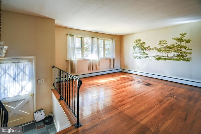 spare room featuring wood-type flooring and a baseboard radiator