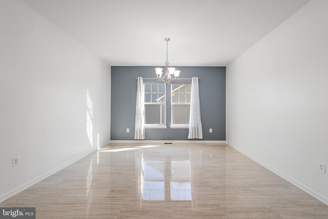 spare room with an inviting chandelier