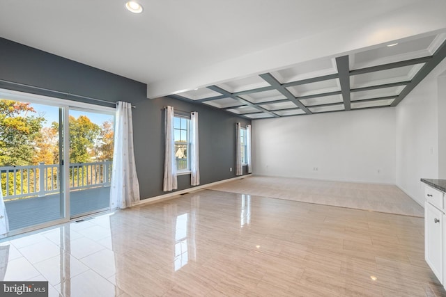 unfurnished room featuring beam ceiling, coffered ceiling, and light tile patterned floors