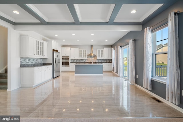 kitchen featuring a kitchen island, decorative backsplash, stainless steel refrigerator with ice dispenser, and white cabinetry