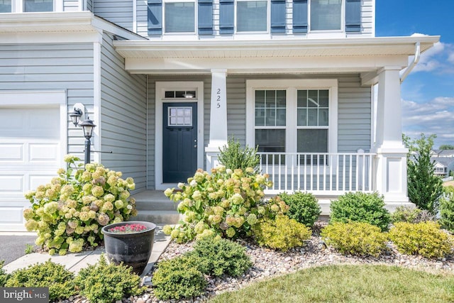 doorway to property featuring a porch and a garage