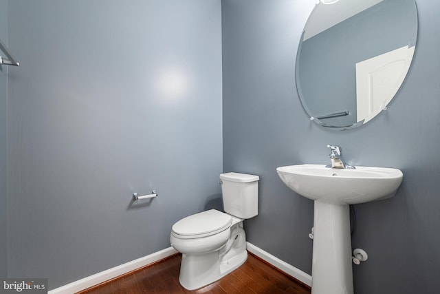 bathroom featuring hardwood / wood-style flooring and toilet