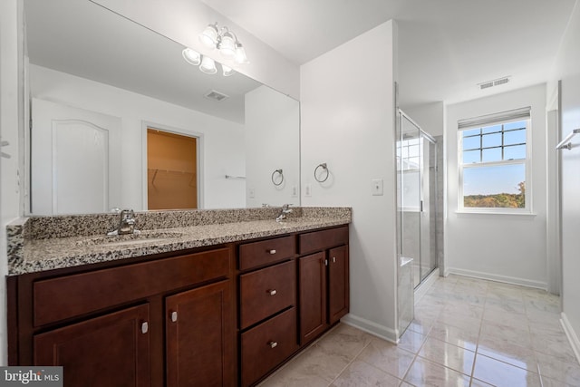 bathroom featuring vanity, walk in shower, and tile patterned flooring