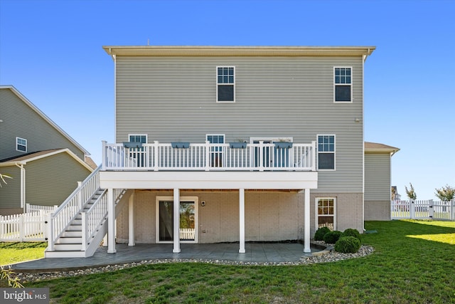 back of house with a patio, a wooden deck, and a lawn