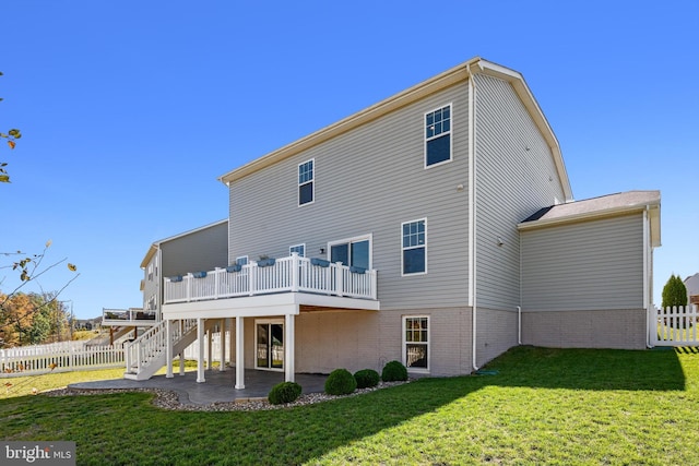 back of house featuring a yard, a patio area, and a deck