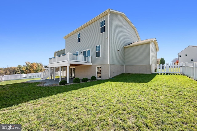 rear view of property featuring a patio, a lawn, and a balcony