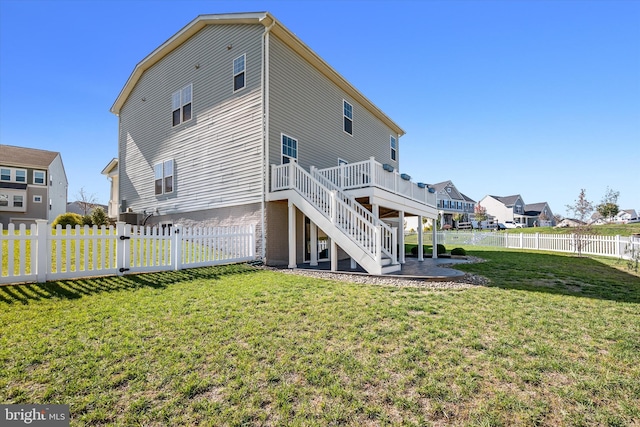 rear view of property with a yard and a deck