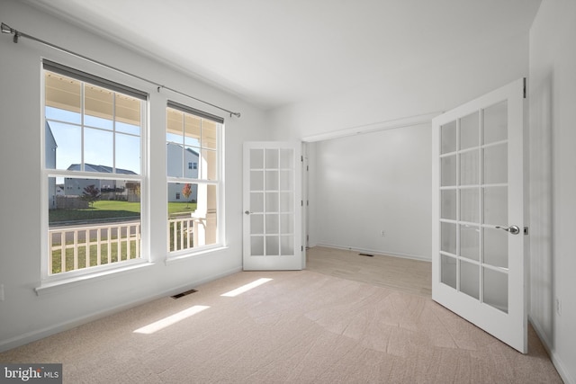 carpeted spare room with french doors