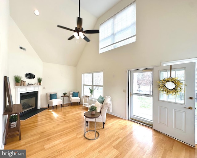 502 Pond Way, Church Hill, MD 21623 - living area with visible vents, a fireplace with flush hearth, wood finished floors, high vaulted ceiling, and a ceiling fan