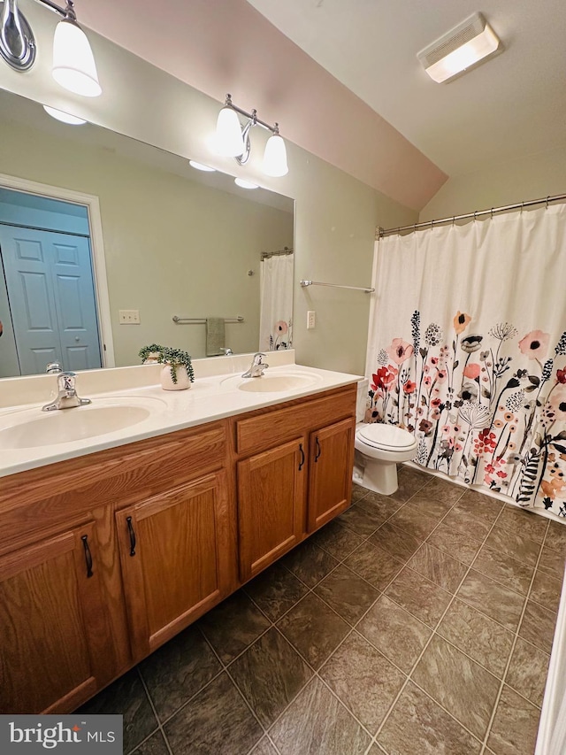 bathroom featuring a shower with shower curtain, vanity, and toilet