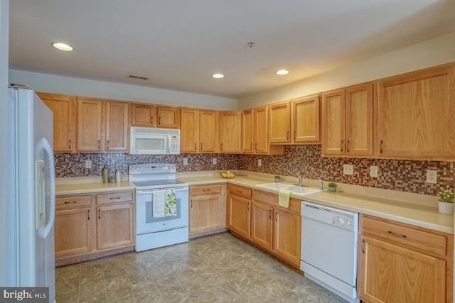 kitchen featuring backsplash, sink, and white appliances