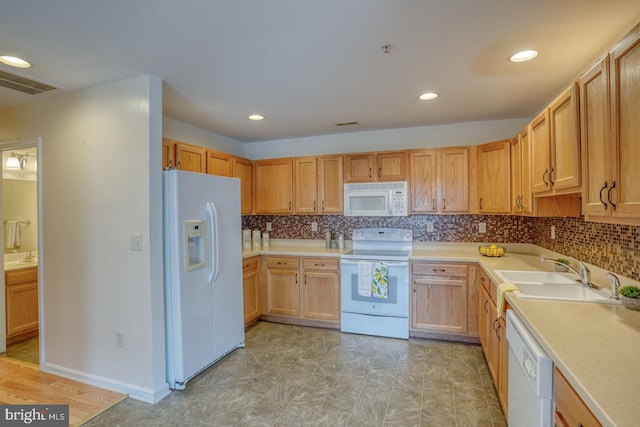 kitchen featuring white appliances, backsplash, and sink