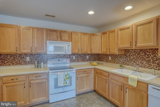 kitchen featuring light brown cabinetry, white appliances, sink, and backsplash