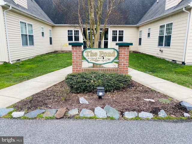 community / neighborhood sign featuring a yard