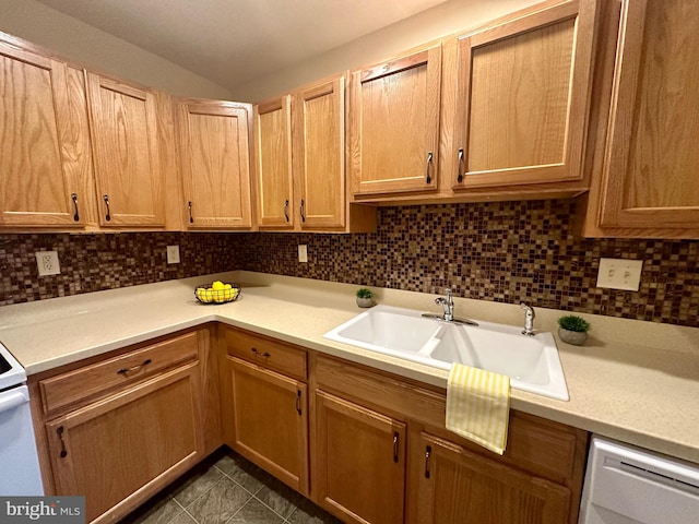 kitchen featuring tasteful backsplash, dishwasher, and sink