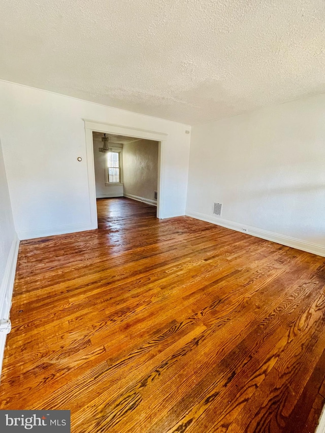 unfurnished room featuring a textured ceiling and wood-type flooring