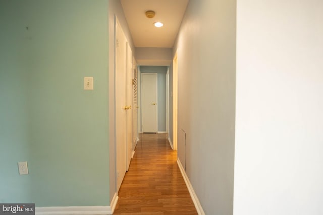 corridor with hardwood / wood-style flooring