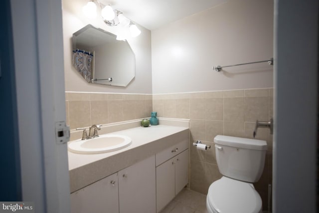 bathroom with vanity, tile walls, tile patterned flooring, and toilet