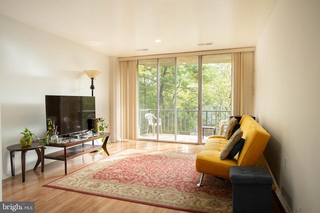 living area with expansive windows and hardwood / wood-style floors