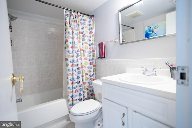 full bathroom with vanity, shower / bath combo with shower curtain, toilet, and tile walls