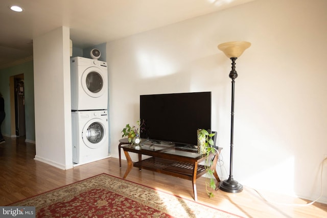 laundry area featuring hardwood / wood-style floors and stacked washer / dryer