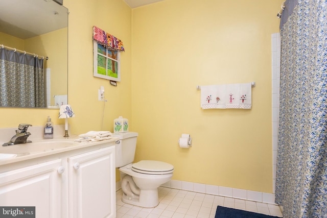 bathroom featuring vanity, tile patterned flooring, toilet, and walk in shower