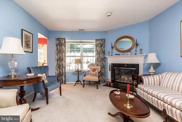 carpeted living room featuring a high end fireplace