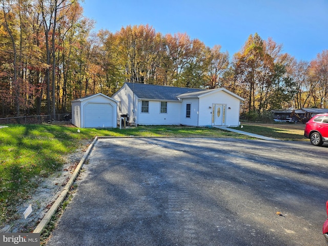 single story home with an outbuilding, a garage, and a front lawn